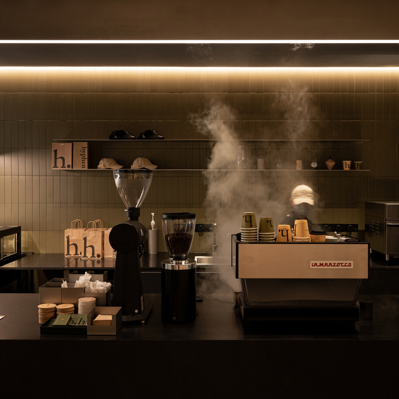 A professional coffee station setup in a dimly lit cafe, featuring a U.S.